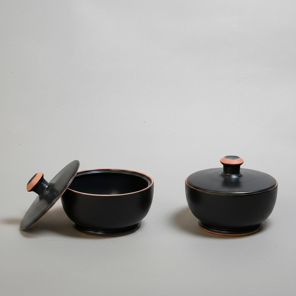 Two black ceramic containers (pyxis) with lids 