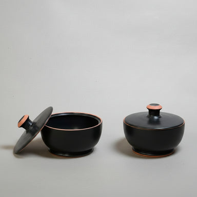 Two black ceramic containers (pyxis) with lids 