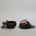 Black and pinkish ceramic containers on a beige fabric background