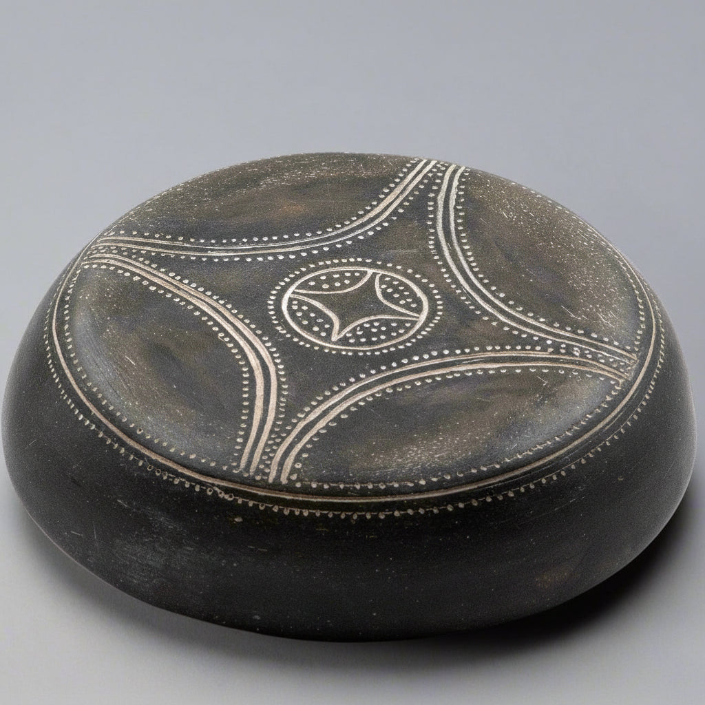 Black stone with white circular design on a gray background