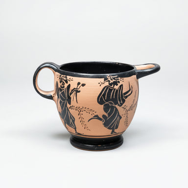 Ceramic cup with black floral and leaf designs on a white background