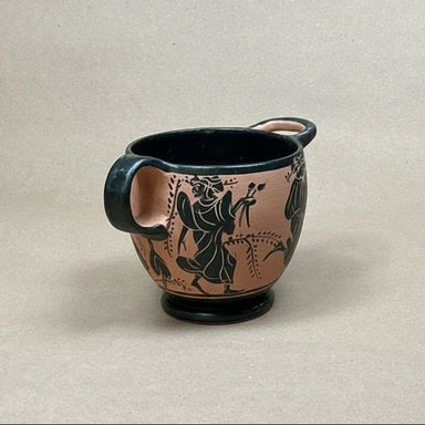 Ceramic cup with black handle and decorative black figures on a beige background