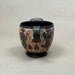Ceramic mug with black decorative patterns on a beige background