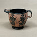 Ceramic cup with black handles and black figures on a beige background