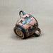 Ceramic cup with black decorative design on a beige background
