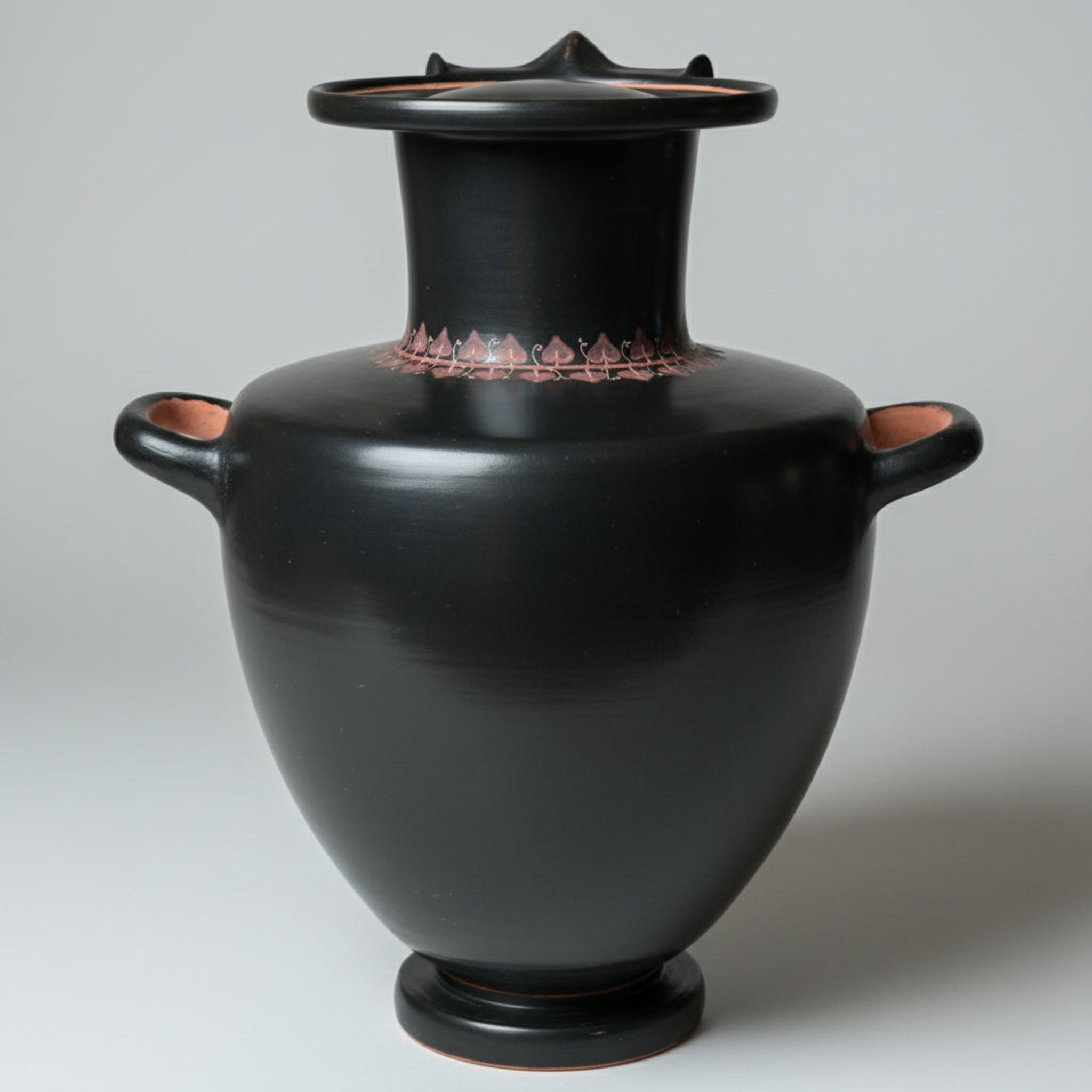 Black ceramic vase with red detailing on a gray background