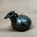 Black ceramic vase with decorative patterns on a beige background