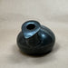 Black stone vase on a beige fabric background