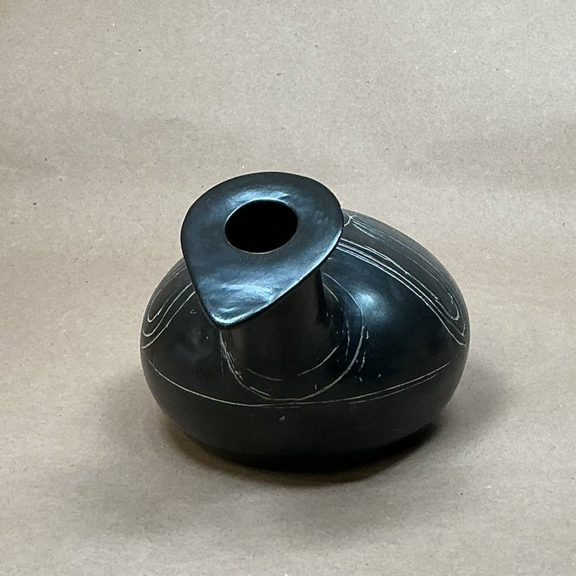 Black stone vase on a beige fabric background