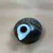 Black ancient greek ceramic replica with a central spout on beige paper