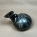 Black ceramic vase with white patterns on a beige background