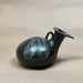 Black decorative vase on a beige surface 