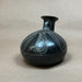Black ceramic vase with white patterns on a beige background