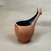 Ceramic vase with black interior on a gray background