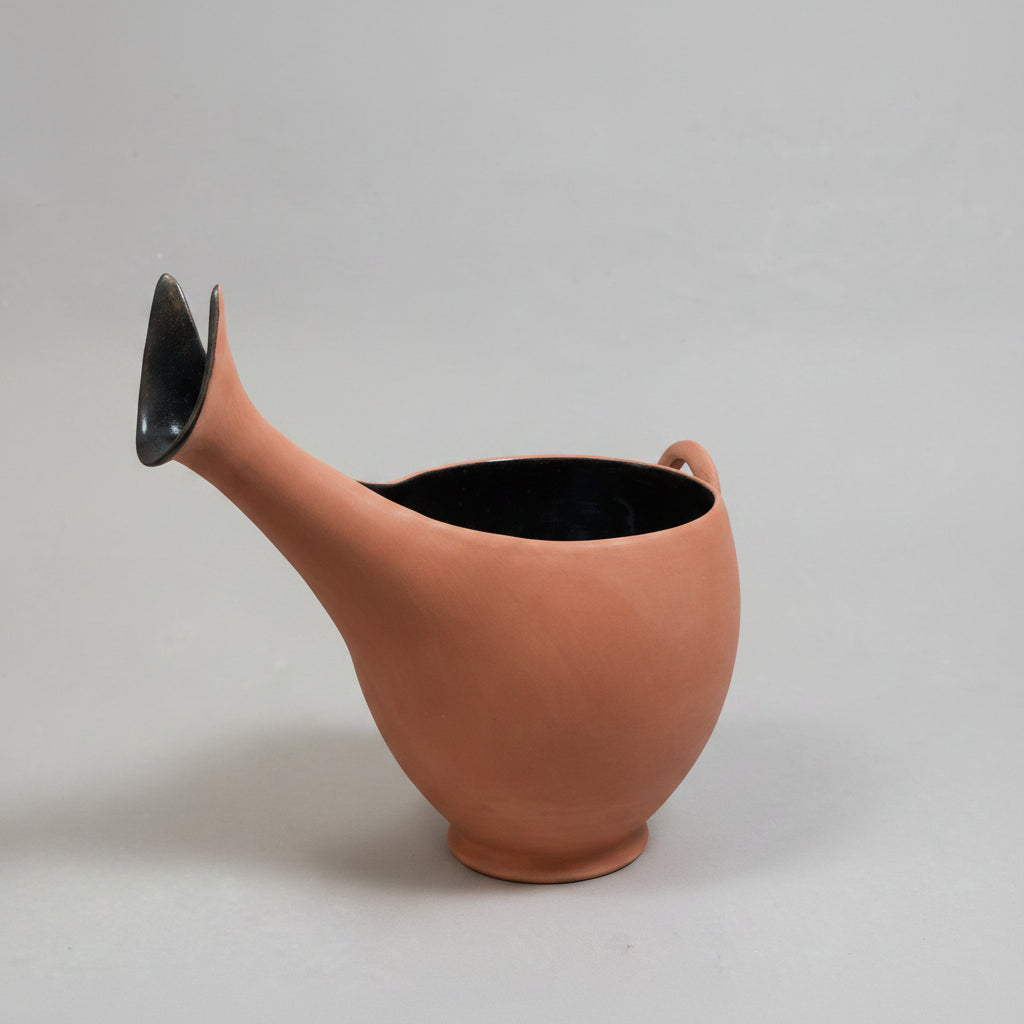 Terracotta-colored watering can on a light gray background