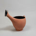 Terracotta-colored watering can on a light gray background