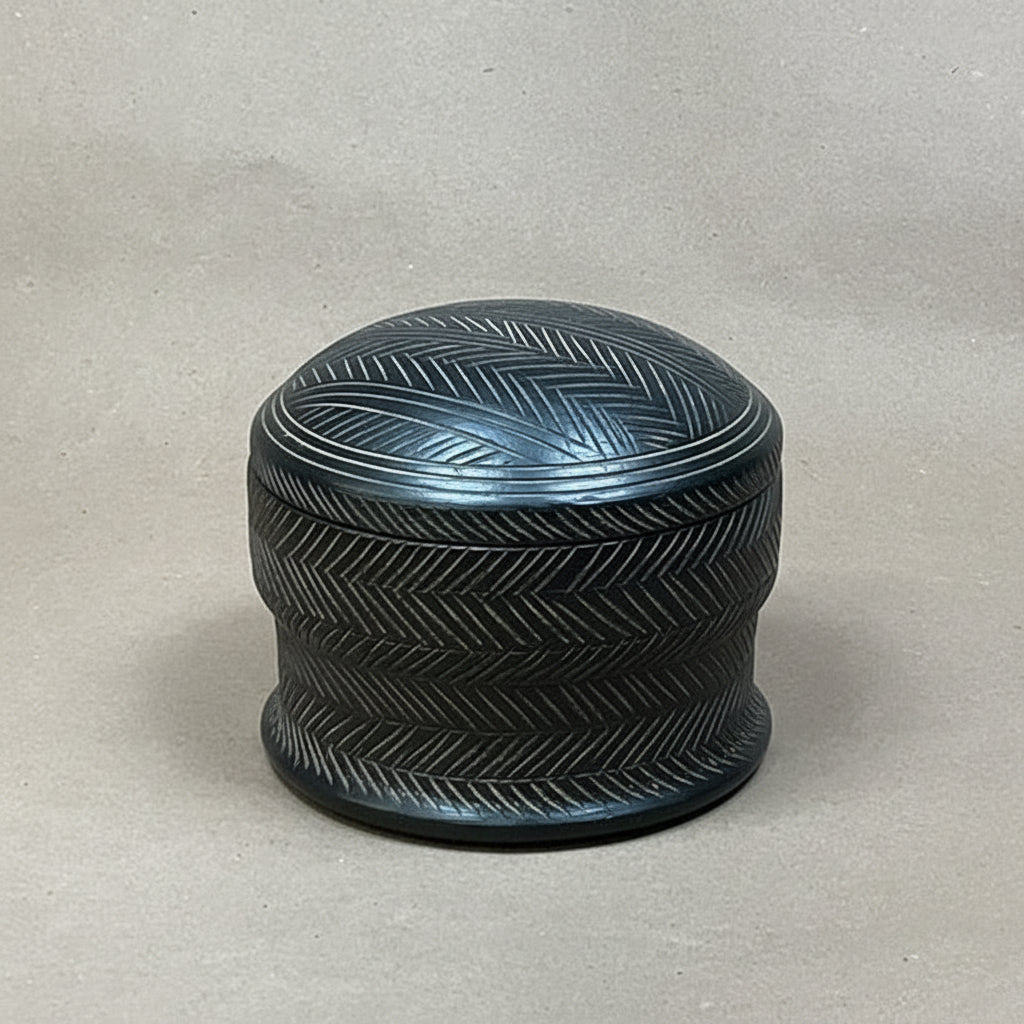 Black textured cylindrical container on a light gray background