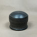 Black textured cylindrical container on a light gray background