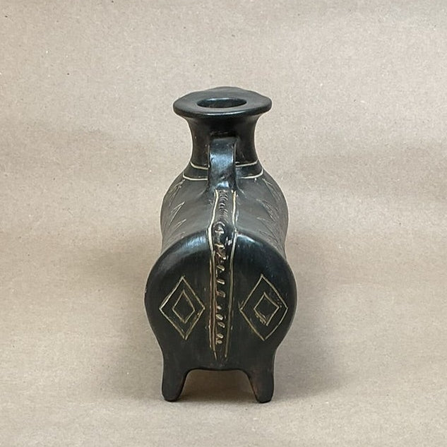 Small decorative vase on a wooden surface with a plain background