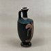Black ceramic vase with red-figure decoration on a white background