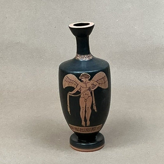 Black vase with red decorative figure on a gray background