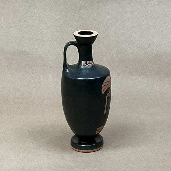 Black ceramic vase with red decorative patterns on a gray background