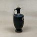 Black ceramic vase with red decorative patterns on a gray background