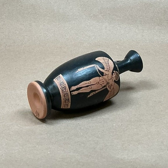 Black ceramic bottle with red decorative elements on a white background