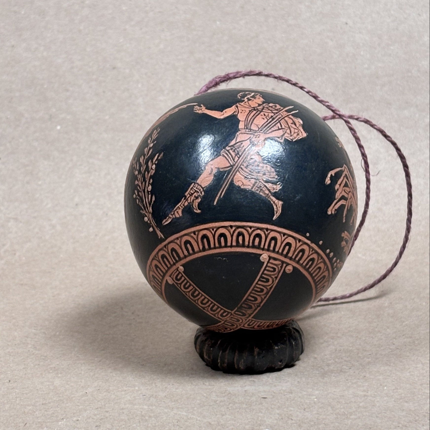 Decorative egg with ancient Greek design on a beige background