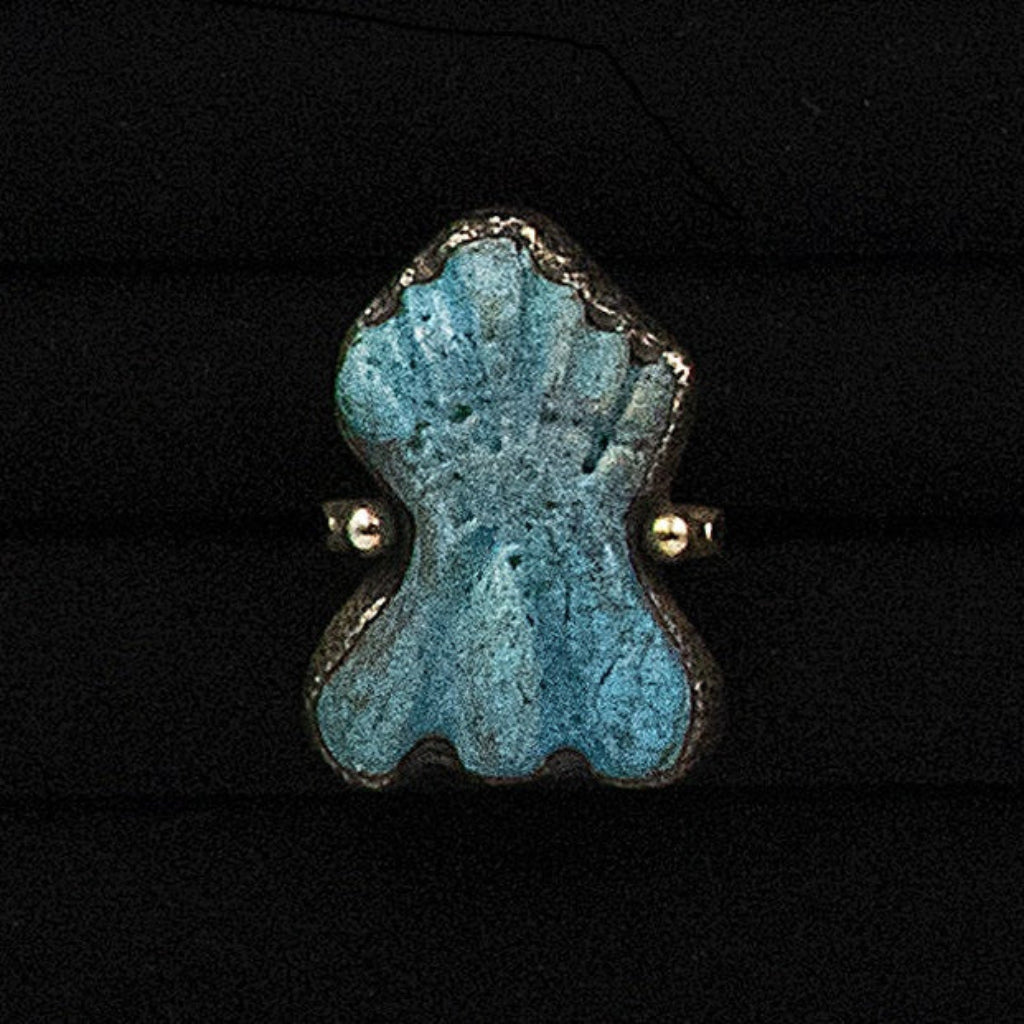 Blue ceramic ring with gold accents on a black background