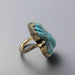 Ring with blue stone and bronze band on a white background