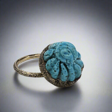 Ring with a textured blue stone on a gray background