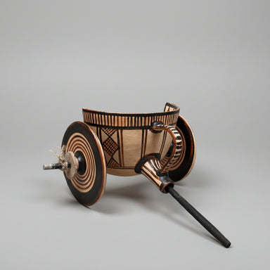 ceramic toy chariot with wheels on a textured beige background