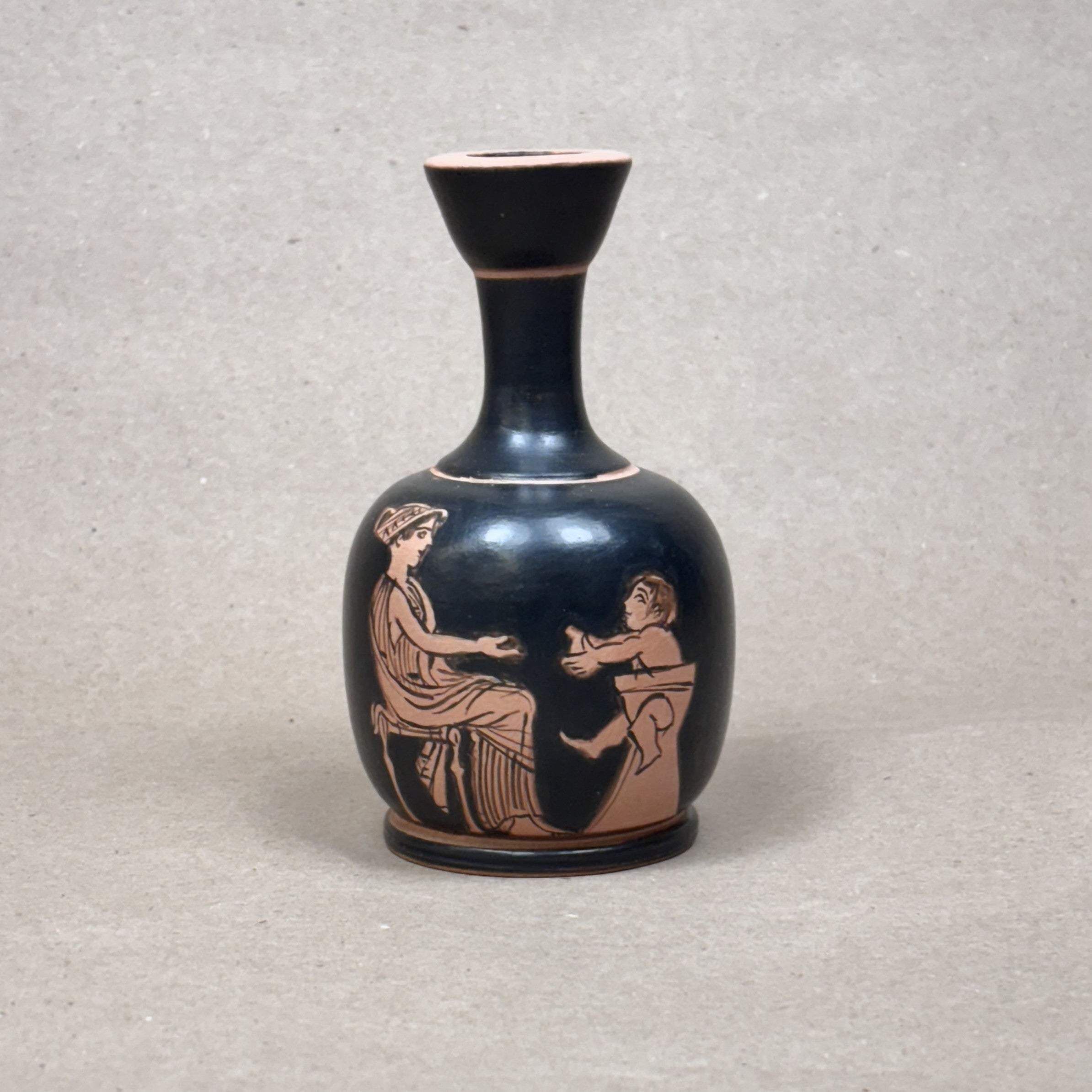 Black vase with red-figure decoration of two figures on a gray background