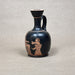 Black ceramic vase with red-figure decoration on a gray background
