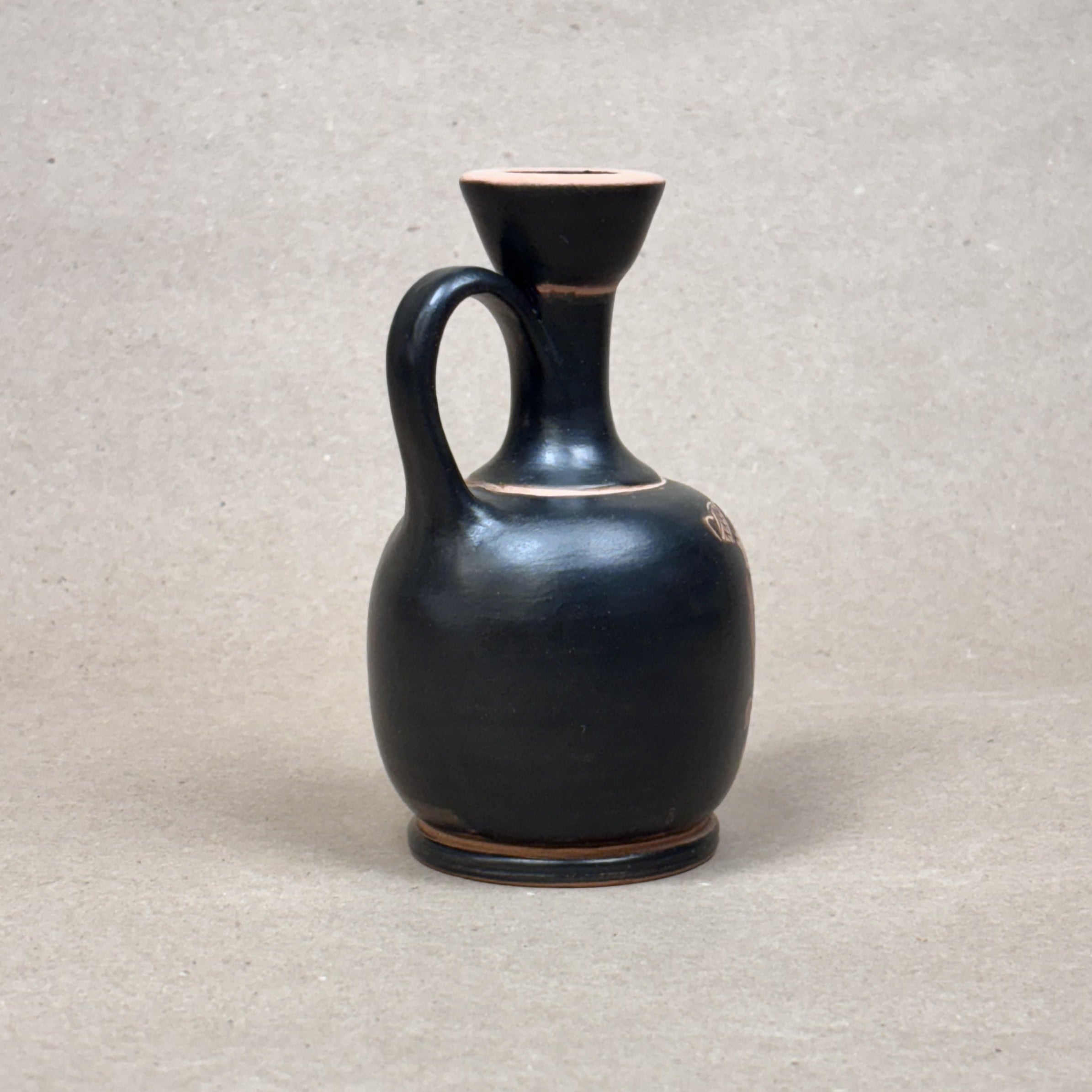 Black ceramic jug on a gray background