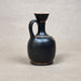 Black ceramic jug on a gray background