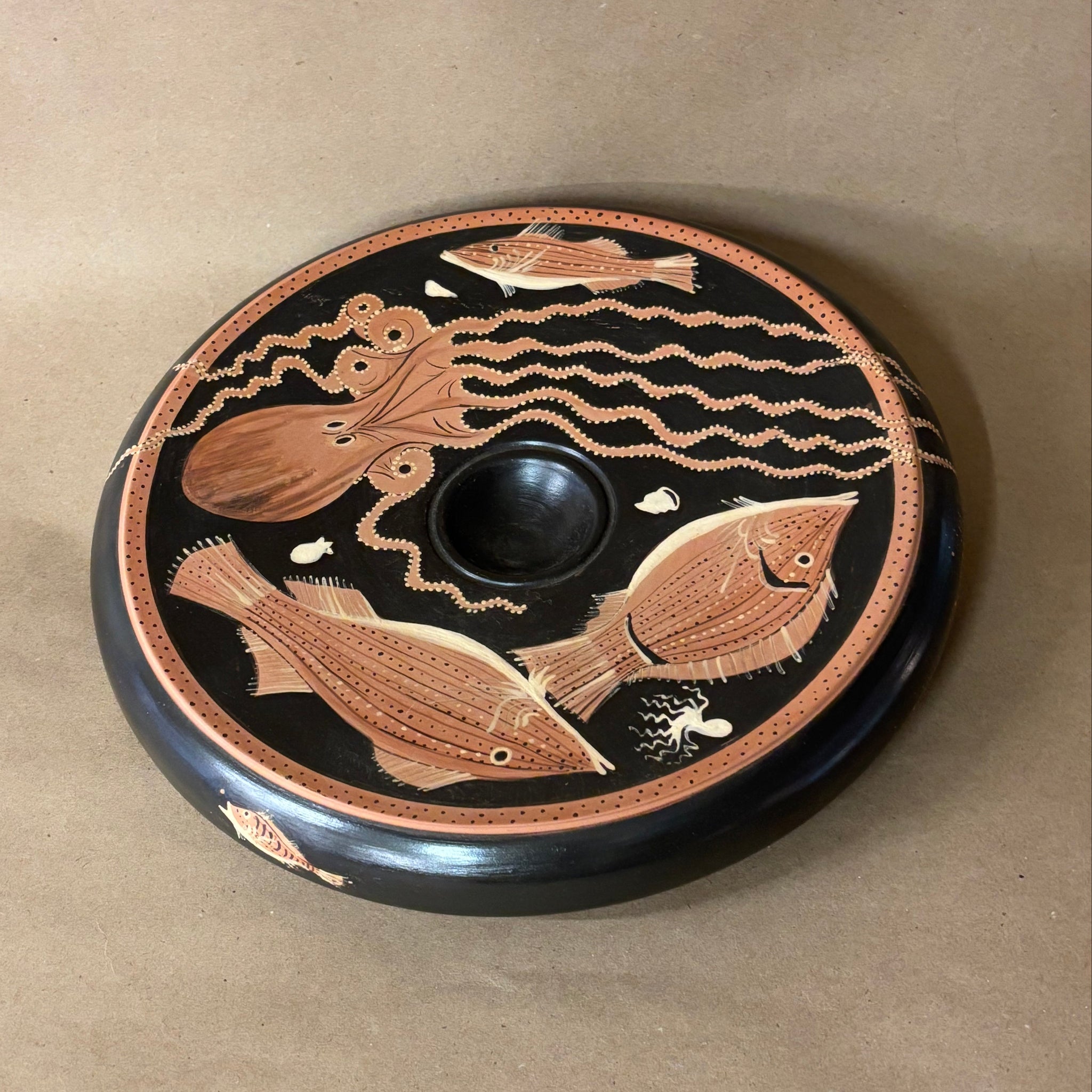 Decorative plate with fish and wave patterns on a beige background
