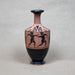 Ceramic vase with black and red design on a gray background