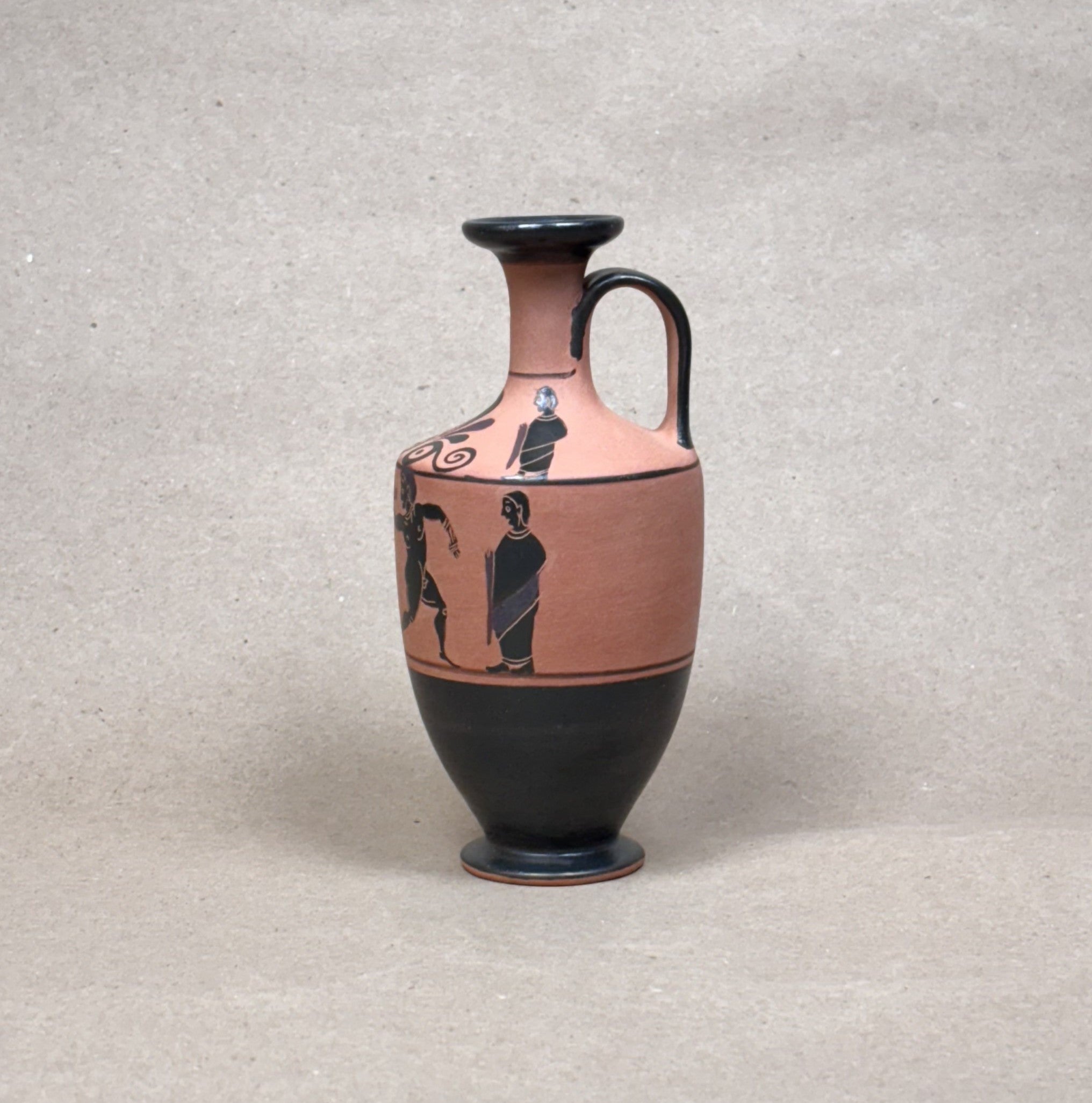 Ceramic vase with black and red design on a gray background