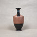 Ceramic vase with black and brown design on a textured beige background