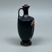 Black ceramic vase with red decorative patterns on a gray background