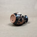Ceramic vase with black and red design on a beige background