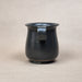 Black ceramic mug with handle on a beige background