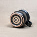 Ceramic mug with black and brown design on a beige background