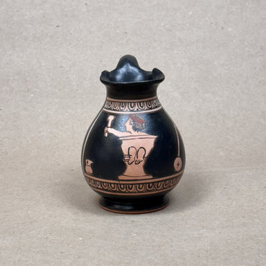 Black ceramic vase with decorative patterns on a gray background