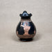 Black ceramic vase with decorative patterns on a gray background