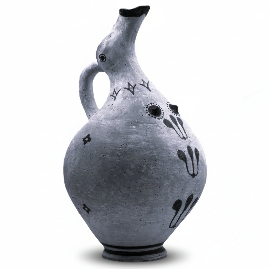 This image features a hand-formed ceramic nippled ewer, known as a Thera breasted jug or Mastoprochos, from the Cyclades dating back to the Middle to early Late Bronze Age. The vessel is crafted to represent both functional and ritualistic uses, highlighted by its distinctive plastic breast-like feature and ornate decorations.