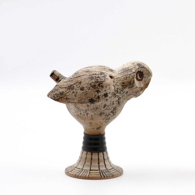 A ceramic whistle shaped like an owl with a beige and brown color palette on a white background.