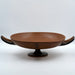 A large coral red ceramic decorative bowl with a black base, displayed against a plain background.